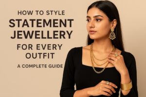 Elegant woman wearing gold statement earrings, layered necklaces, and rings, showcasing how to style statement jewellery for different outfits.